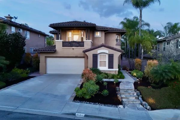 a front view of a house with a yard and potted plants