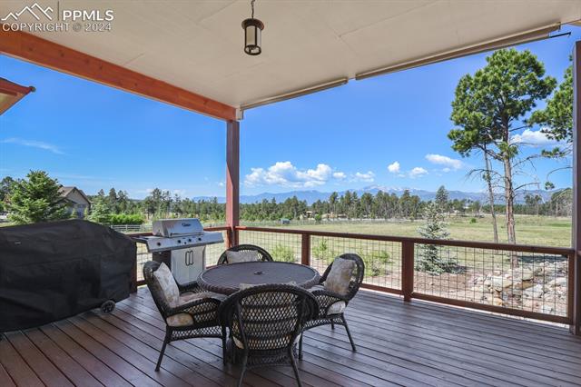 12810 Holmes Road Colorado Springs, CO 80908 - Photo 33 of 45 Wooden Terrace featuring Grilling With Gas Hookup and a Waterfall and Unobstructed Pikes Peak Views
