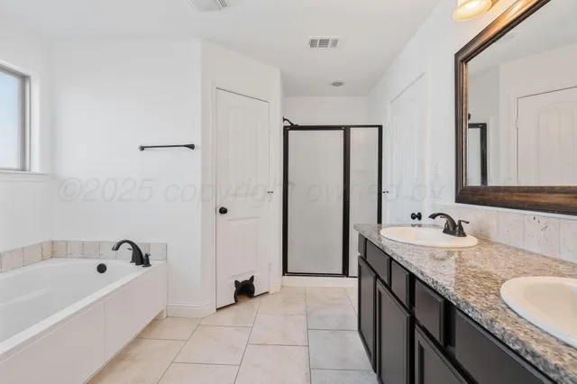a spacious bathroom with a granite countertop tub sink and mirror