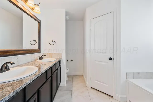 a spacious bathroom with a granite countertop sink and a mirror
