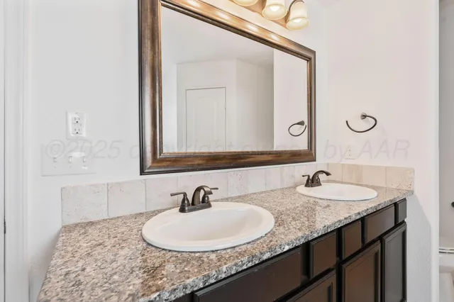 a bathroom with a granite countertop sink and a mirror