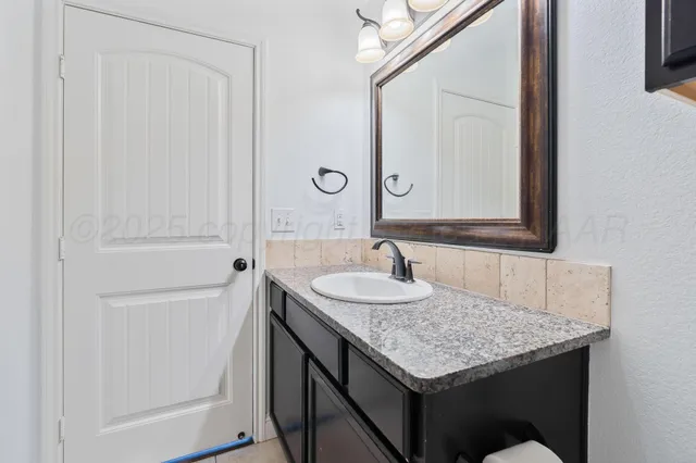 a bathroom with a granite countertop sink and a mirror