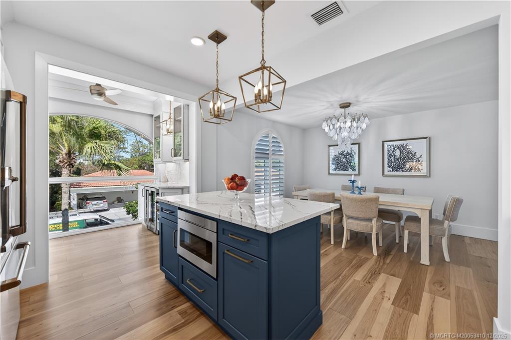 12445 Harbour Ridge Boulevard, Unit 38 Palm City, FL 34990 - Photo 20 of 46 a kitchen with a stove dining table chairs and a floor to ceiling window