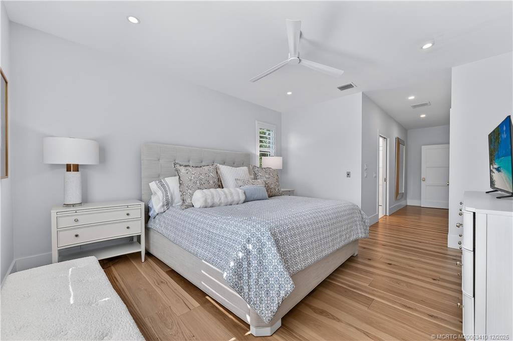 12445 Harbour Ridge Boulevard, Unit 38 Palm City, FL 34990 - Photo 24 of 46 a spacious bedroom with a bed and a lamp