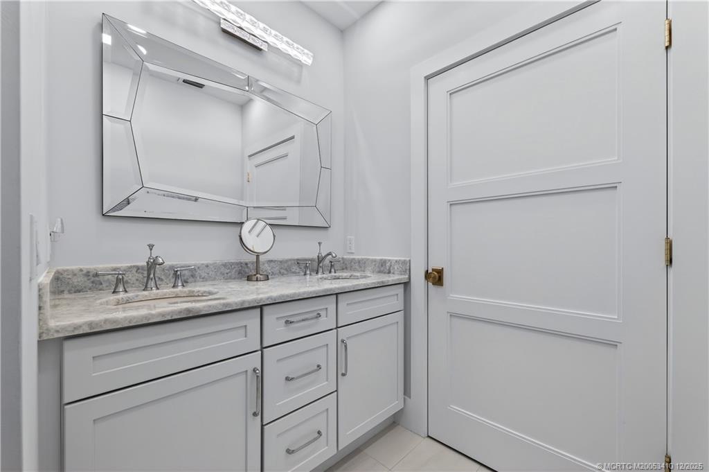 12445 Harbour Ridge Boulevard, Unit 38 Palm City, FL 34990 - Photo 26 of 46 a bathroom with a granite countertop sink and a mirror