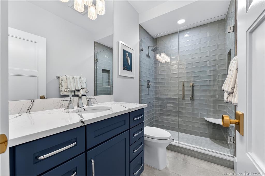 12445 Harbour Ridge Boulevard, Unit 38 Palm City, FL 34990 - Photo 30 of 46 a bathroom with a sink a toilet a mirror and shower