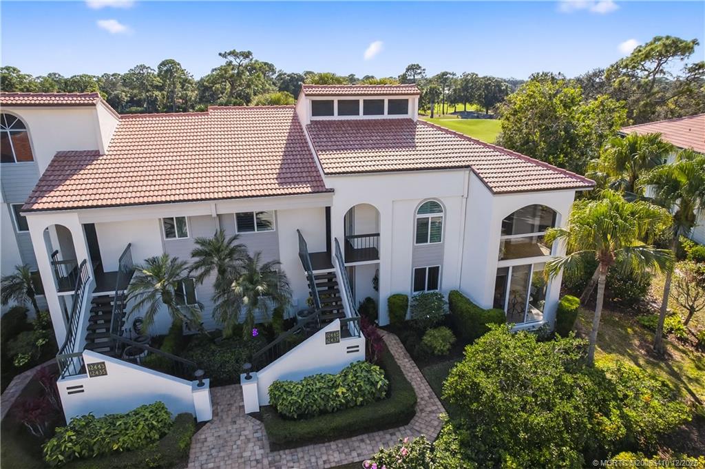 12445 Harbour Ridge Boulevard, Unit 38 Palm City, FL 34990 - Photo 36 of 46 a view of a white house with a yard and potted plants