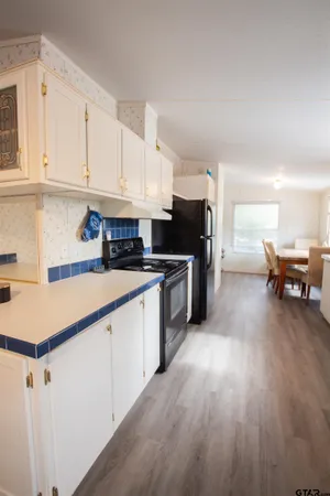 a kitchen with granite countertop a sink cabinets and stainless steel appliances