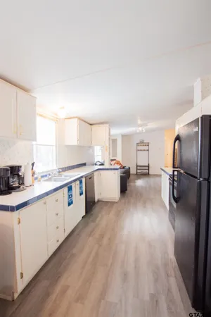 a large kitchen with a lot of counter space and a wooden floor