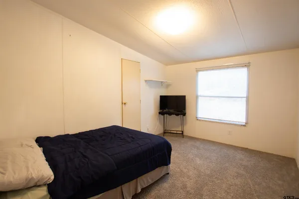 a spacious bedroom with a bed and a window