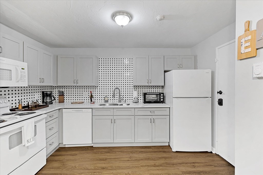 46 Gibbs Street, Unit 1D Worcester, MA 01607 - Photo 6 of 17 a kitchen with white cabinets and white appliances