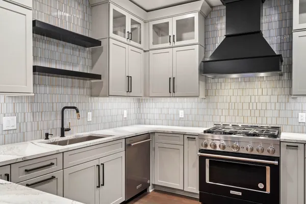 a kitchen with stainless steel appliances a sink stove and cabinets