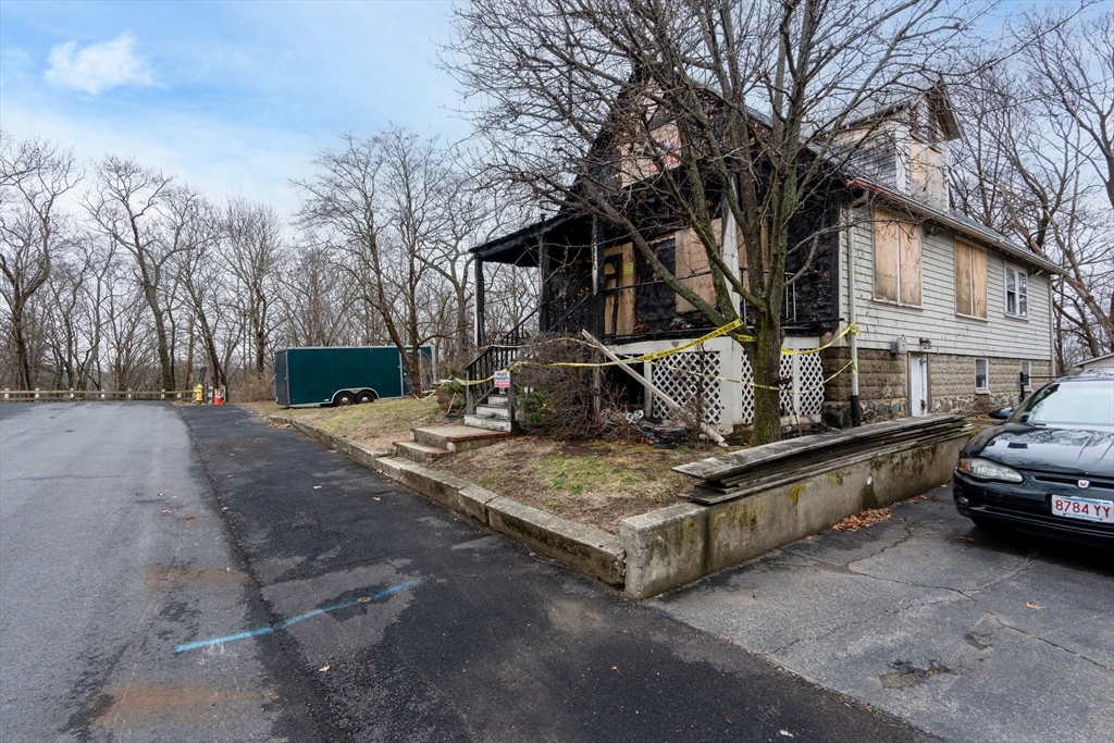 111 Schiller Road Dedham, MA 02026 - Photo 8 of 10 a view of a house with truck parked on a road next to a building