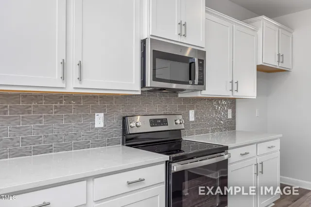 a bedroom with a bed and a lamp on dresser