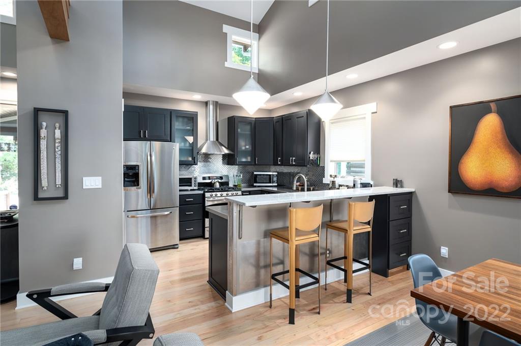 9 Kenilworth Road Asheville, NC 28803 - Photo 6 of 33 a kitchen with stainless steel appliances kitchen island granite countertop a table chairs sink and cabinets