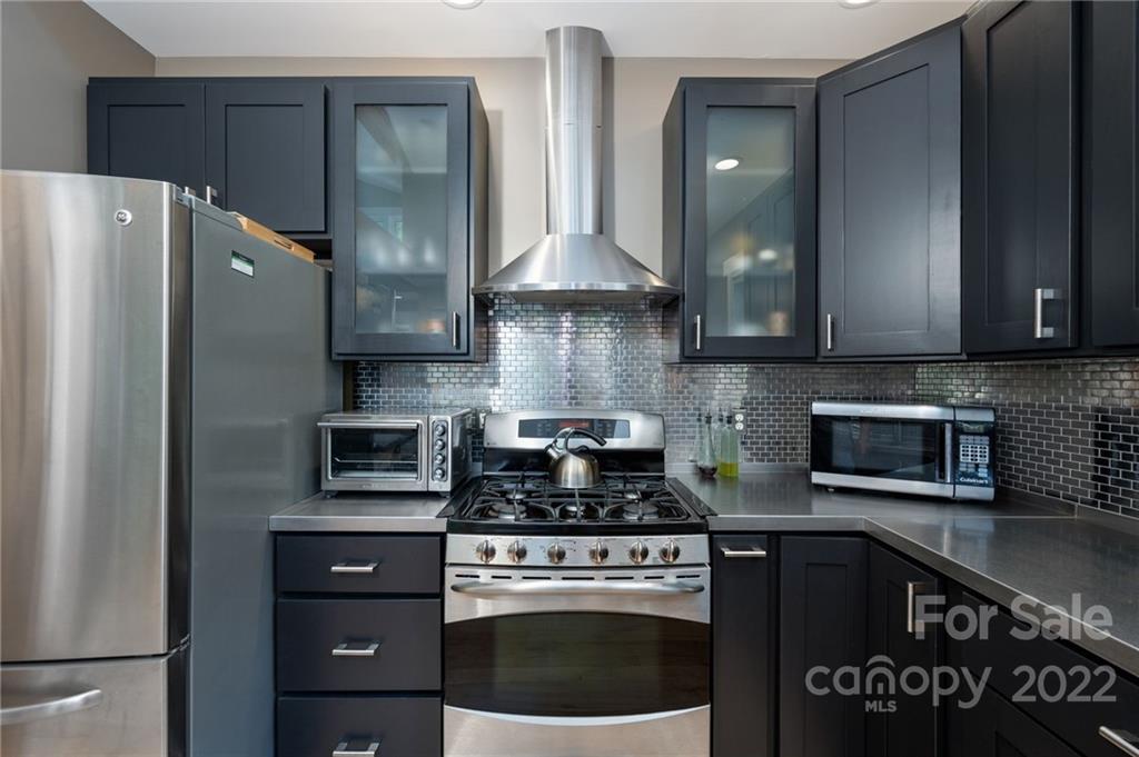 9 Kenilworth Road Asheville, NC 28803 - Photo 8 of 33 a kitchen with stainless steel appliances granite countertop a stove a refrigerator and a microwave
