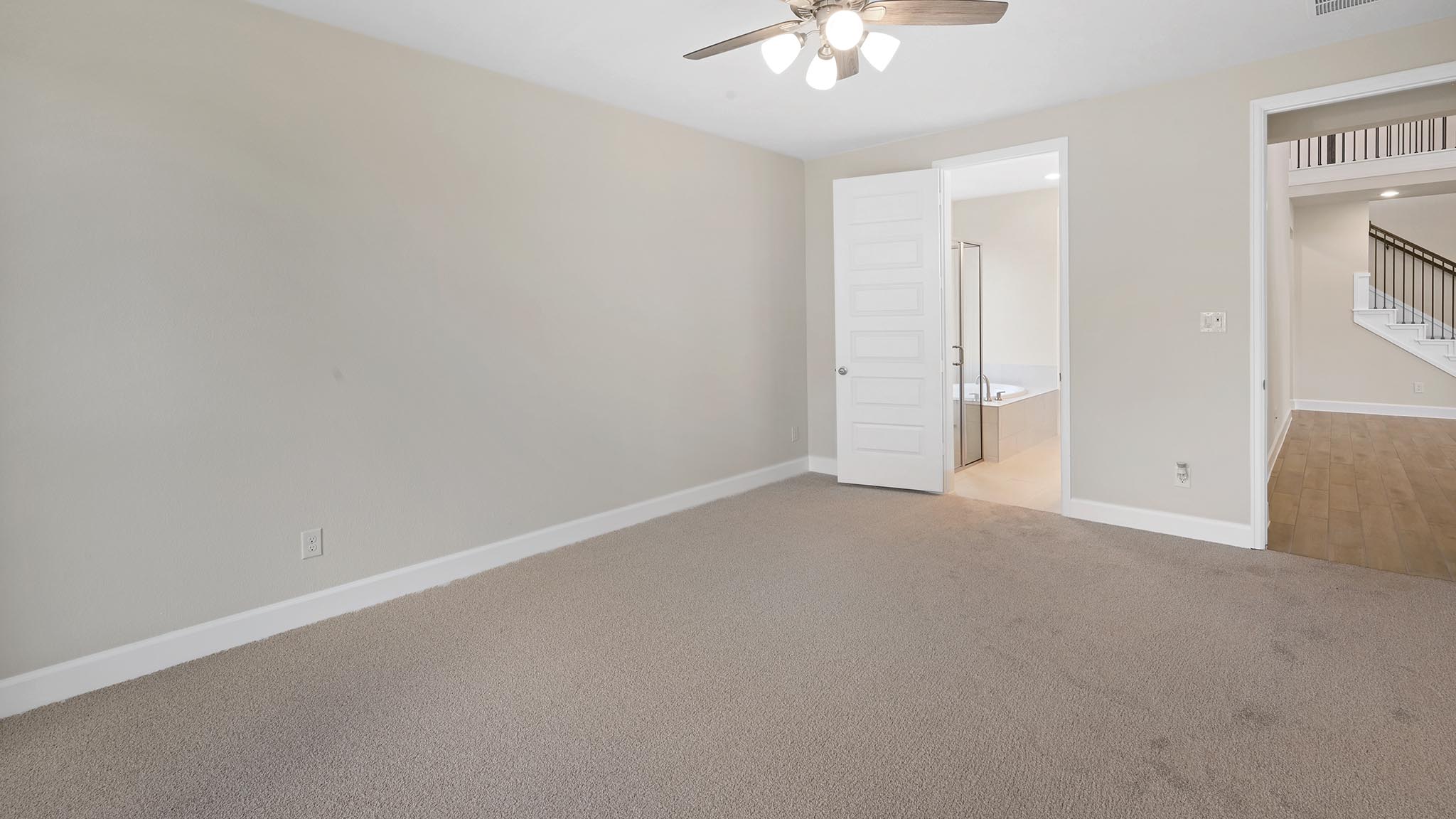 338 Prickly Poppy Loop Kyle, TX 78640 - Photo 18 of 40 Unfurnished bedroom featuring carpet flooring, ceiling fan, and connected bathroom
