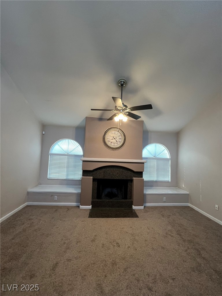 9325 West Desert Inn Road, Unit 206 Las Vegas, NV 89117 - Photo 14 of 37 Unfurnished living room with carpet, a fireplace with flush hearth, and ceiling fan