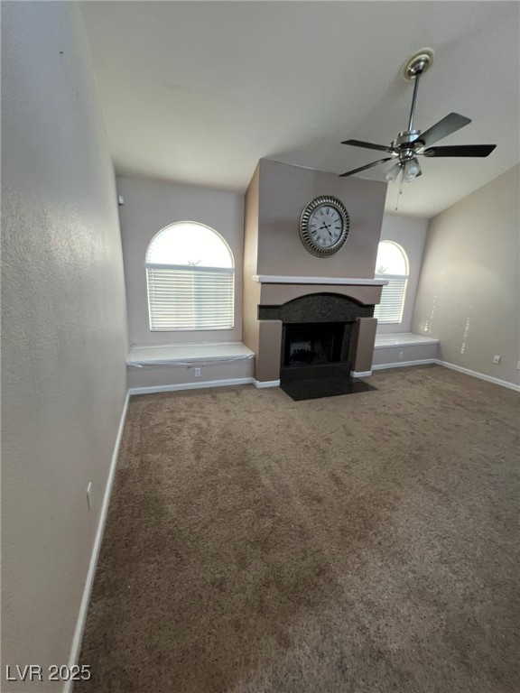 9325 West Desert Inn Road, Unit 206 Las Vegas, NV 89117 - Photo 2 of 37 Unfurnished living room featuring a fireplace with flush hearth, carpet floors, and a ceiling fan