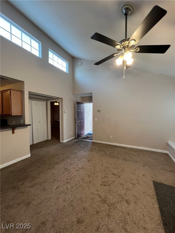 9325 West Desert Inn Road, Unit 206 Las Vegas, NV 89117 - Photo 32 of 37 Unfurnished living room featuring a towering ceiling, dark colored carpet, plenty of natural light, and ceiling fan