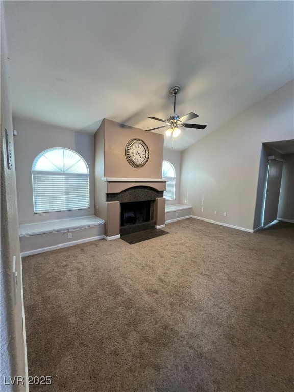 9325 West Desert Inn Road, Unit 206 Las Vegas, NV 89117 - Photo 6 of 37 Unfurnished living room featuring vaulted ceiling, a fireplace with flush hearth, carpet floors, and ceiling fan