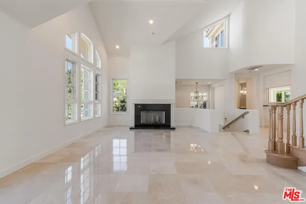 a view of a big room with fireplace and windows