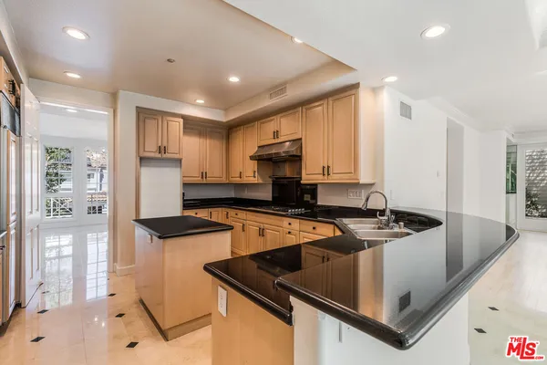 a kitchen that has a sink a stove and a refrigerator