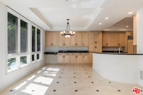 a large kitchen with kitchen island a sink a counter space and stainless steel appliances