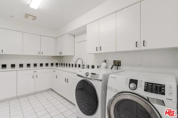 a utility room with sink dryer and washer