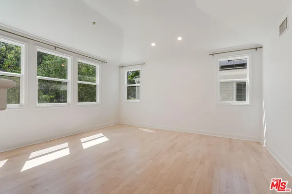 an empty room with a fireplace and windows