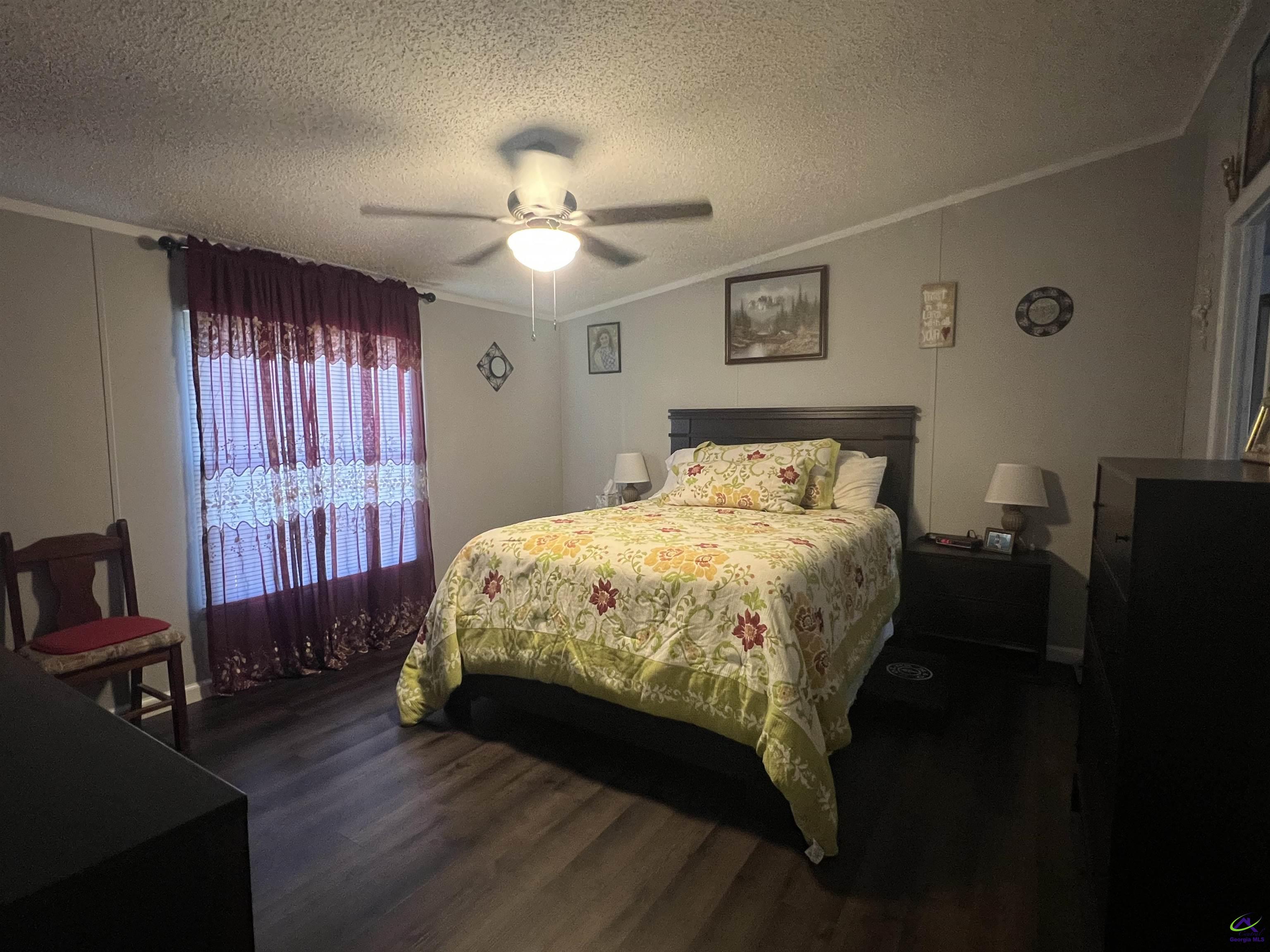 166 Pebble Hills Road Cochran, GA 31014 - Photo 18 of 27 a bedroom with a bed and wooden floor