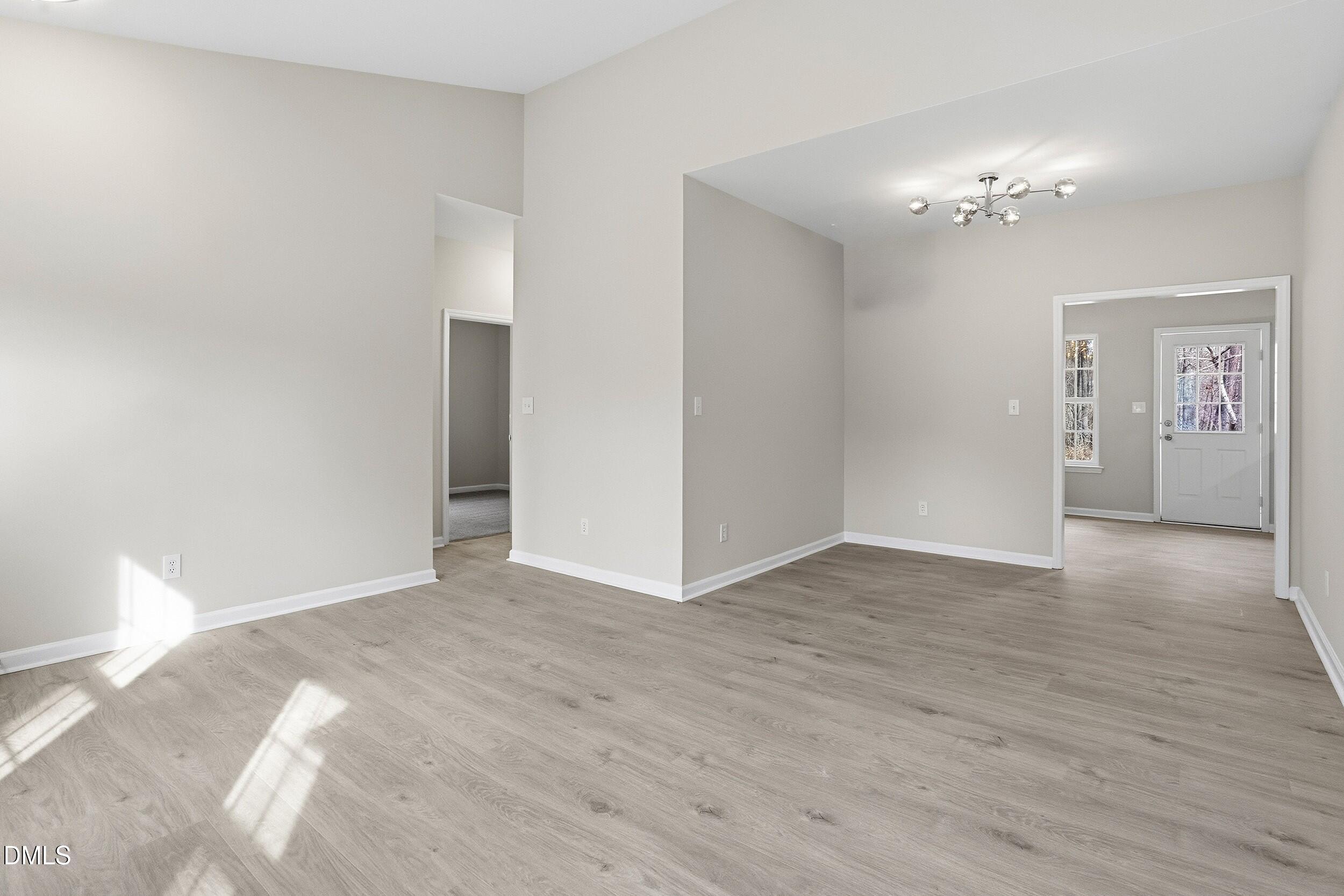 2020 Collier Road Durham, NC 27707 - Photo 14 of 32 a view of a big room with wooden floor and chandelier