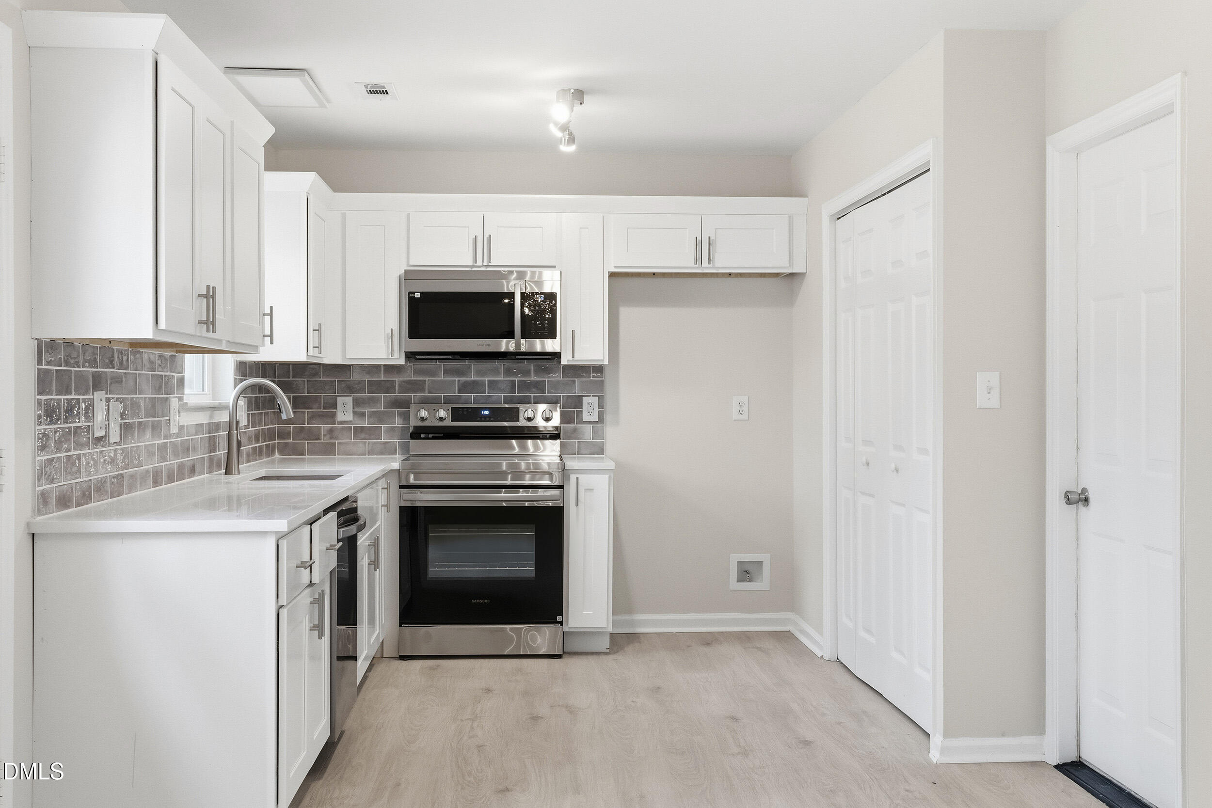 2020 Collier Road Durham, NC 27707 - Photo 9 of 32 a kitchen with stainless steel appliances granite countertop a stove top oven a sink and a refrigerator with wooden floor