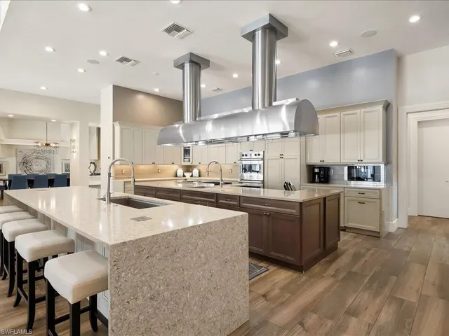 a large kitchen with kitchen island a large island in it