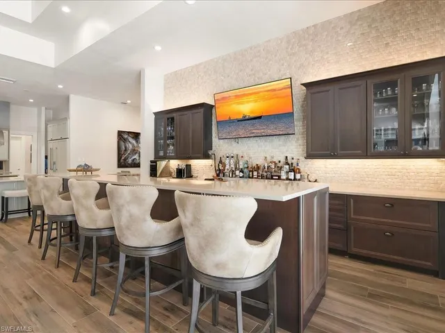 a kitchen with a dining table chairs and white cabinets