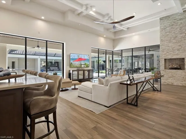 a living room with furniture a ceiling fan and a floor to ceiling window