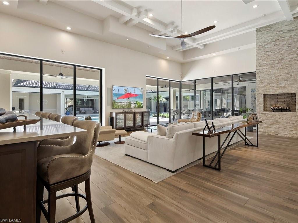 656 Hickory Road Naples, FL 34108 - Photo 15 of 50 a living room with furniture a ceiling fan and a floor to ceiling window