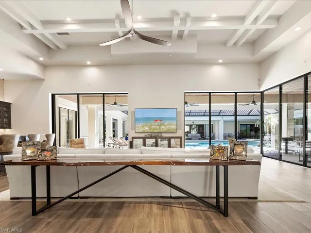 a kitchen with stainless steel appliances kitchen island granite countertop a stove and white cabinets with wooden floor