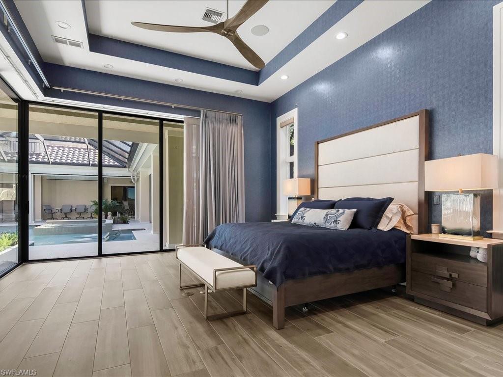 656 Hickory Road Naples, FL 34108 - Photo 18 of 50 a bedroom with a bed and a large window with balcony view