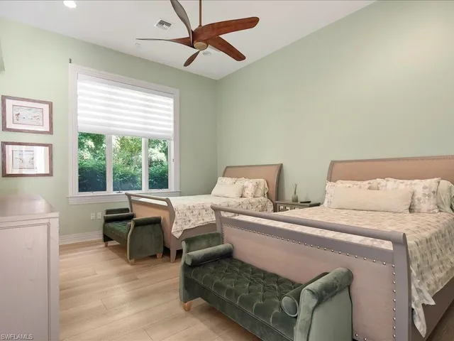 a bed room with two bed and a window