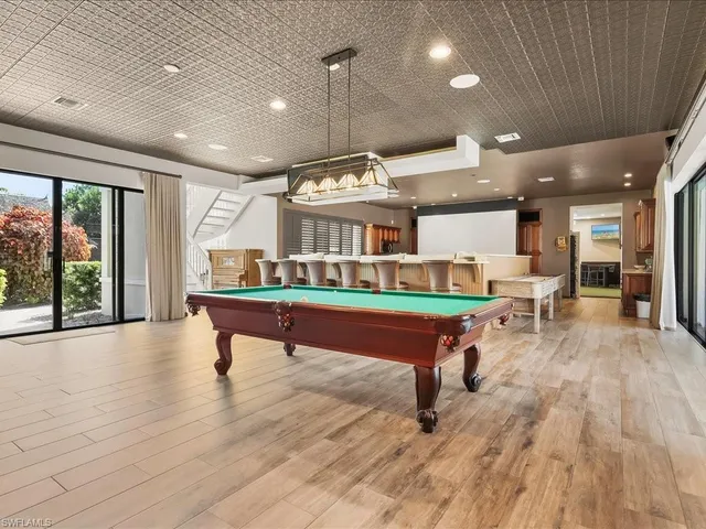 a room with pool table and windows