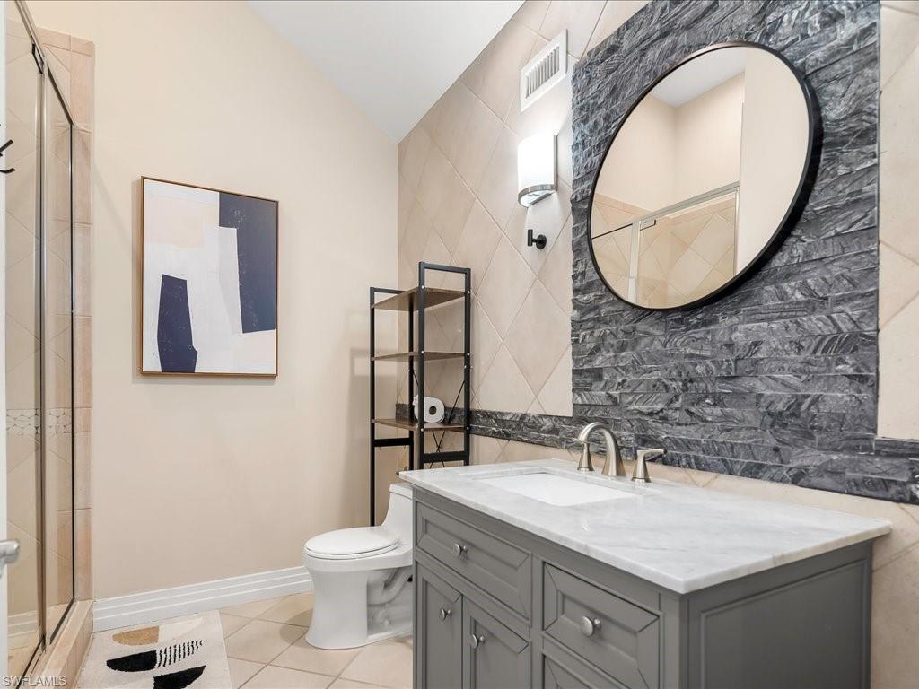 656 Hickory Road Naples, FL 34108 - Photo 40 of 50 a bathroom with a toilet a sink and a mirror