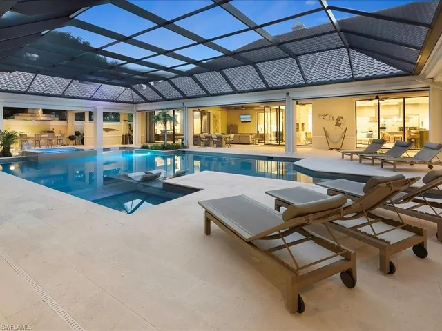 a view of a patio with couches and a fire pit with wooden fence