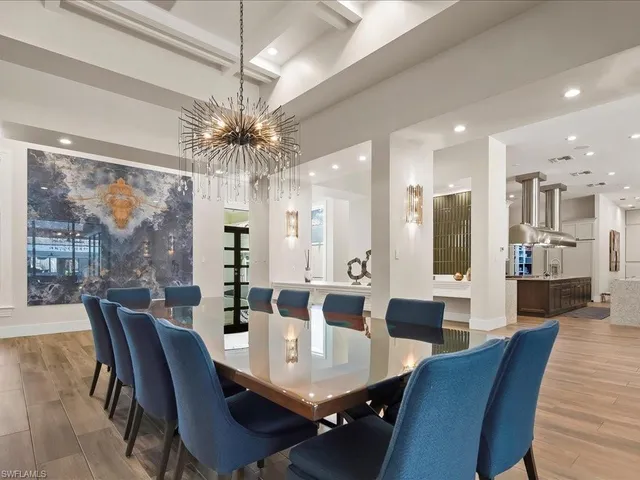 a view of a dining room with furniture a chandelier and wooden floor