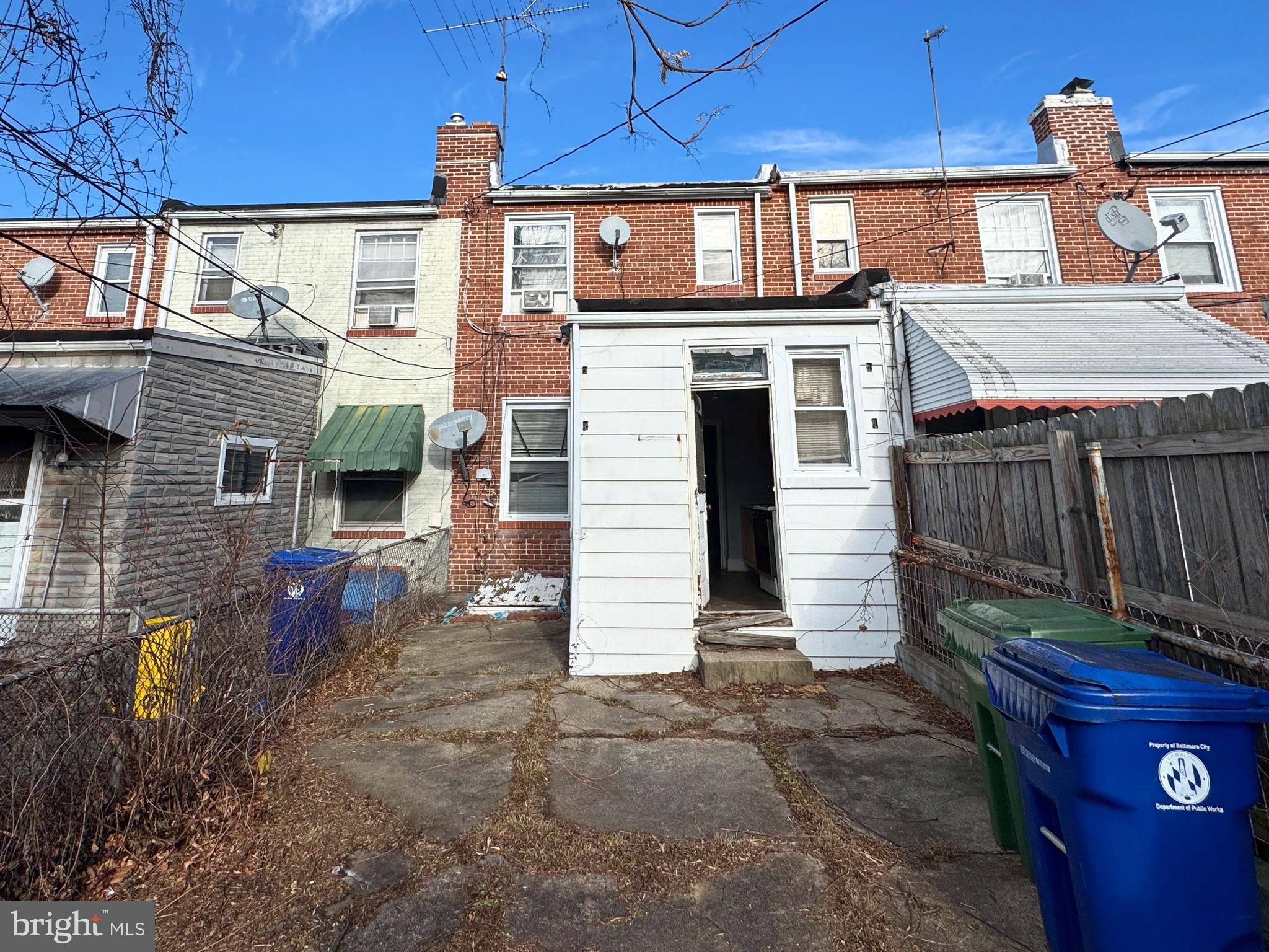 3323 Kenyon Avenue Baltimore, MD 21213 - Photo 3 of 20 a view of a house with a yard and wooden fence
