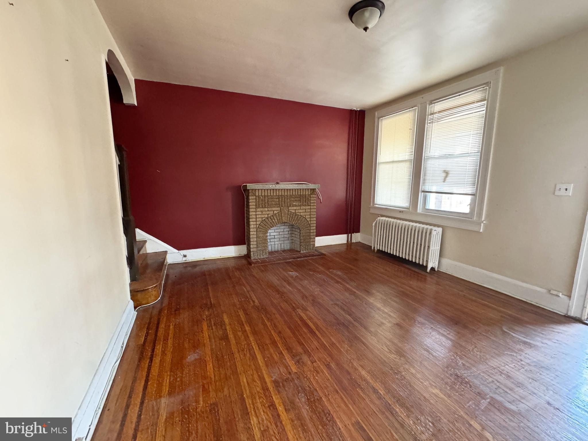 3323 Kenyon Avenue Baltimore, MD 21213 - Photo 5 of 20 a view of an empty room with wooden floor and a window