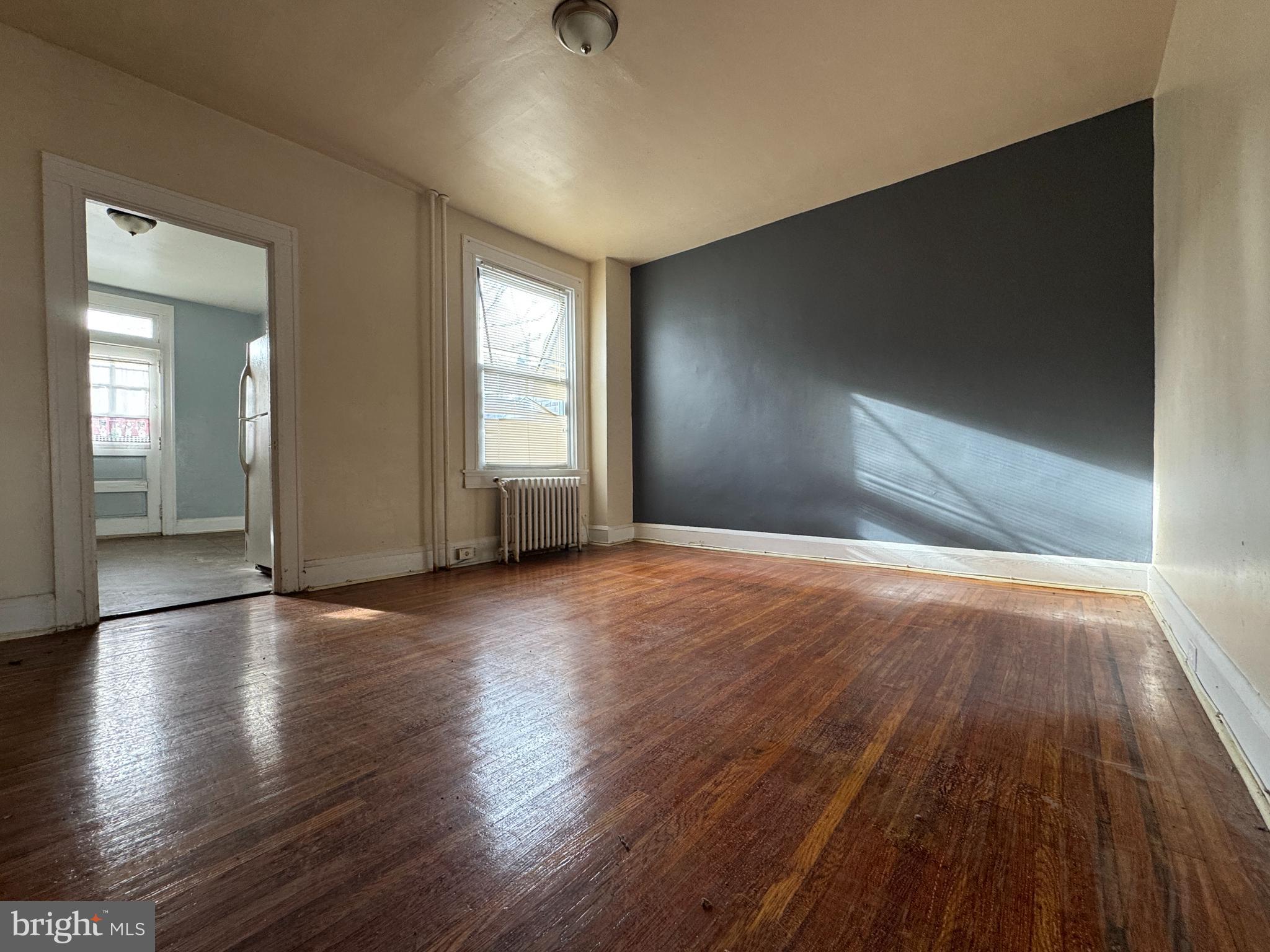 3323 Kenyon Avenue Baltimore, MD 21213 - Photo 8 of 20 an empty room with wooden floor and windows