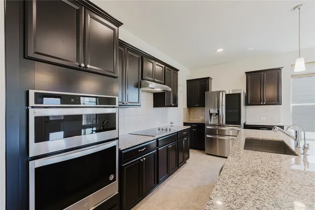 a kitchen with stainless steel appliances granite countertop a stove microwave and refrigerator