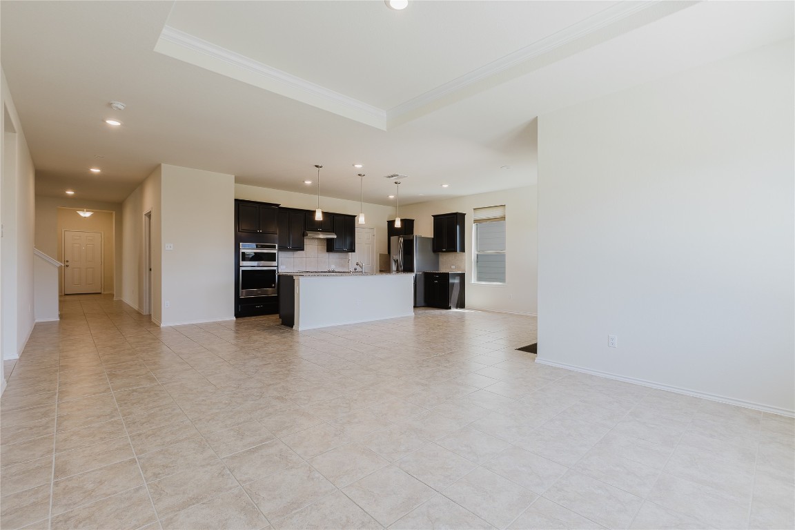 529 Gray Hawk Ridge Leander, TX 78641 - Photo 14 of 36 Unfurnished living room featuring recessed lighting, crown molding, and light tile patterned floors