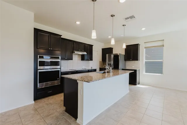 a large white kitchen with a large counter top appliances and cabinets